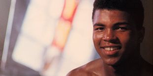 Head and bare shoulders of Muhammad Ali with a blurry background