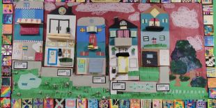 A colorful, 3D cityscape by student artists made of paper. 