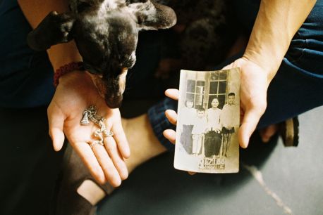 man sitting with his dog holding fragments of material, paper