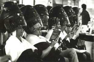 Women sitting in a row at hair dryers