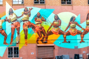 A colorful mural on a brick wall shows the same woman dancing in 7 poses.
